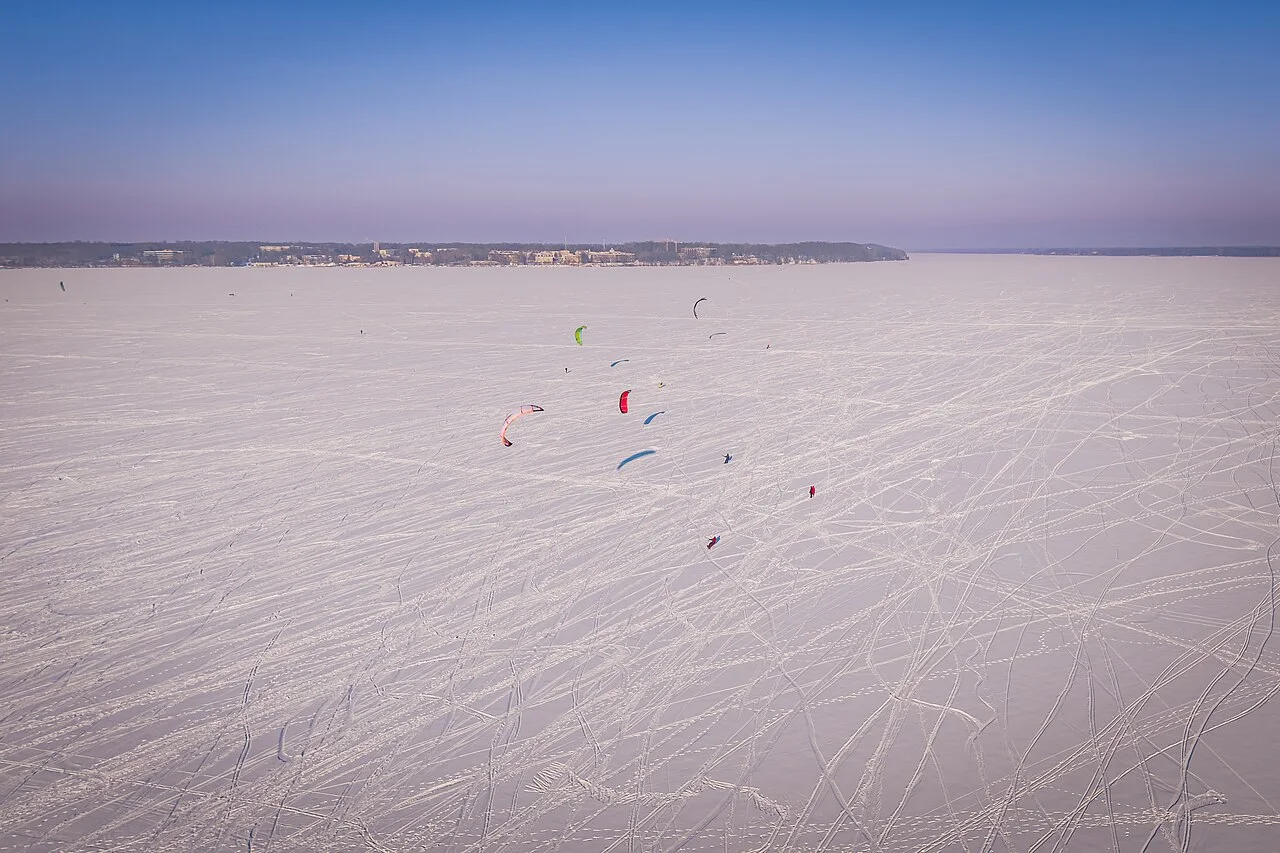 Snowkites above a snowy landscape